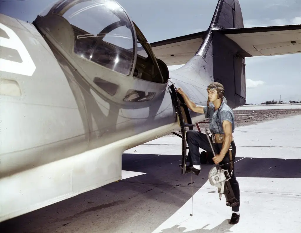 Sailor installing a Browning machine gun in the waist blister of a PBY Catalina